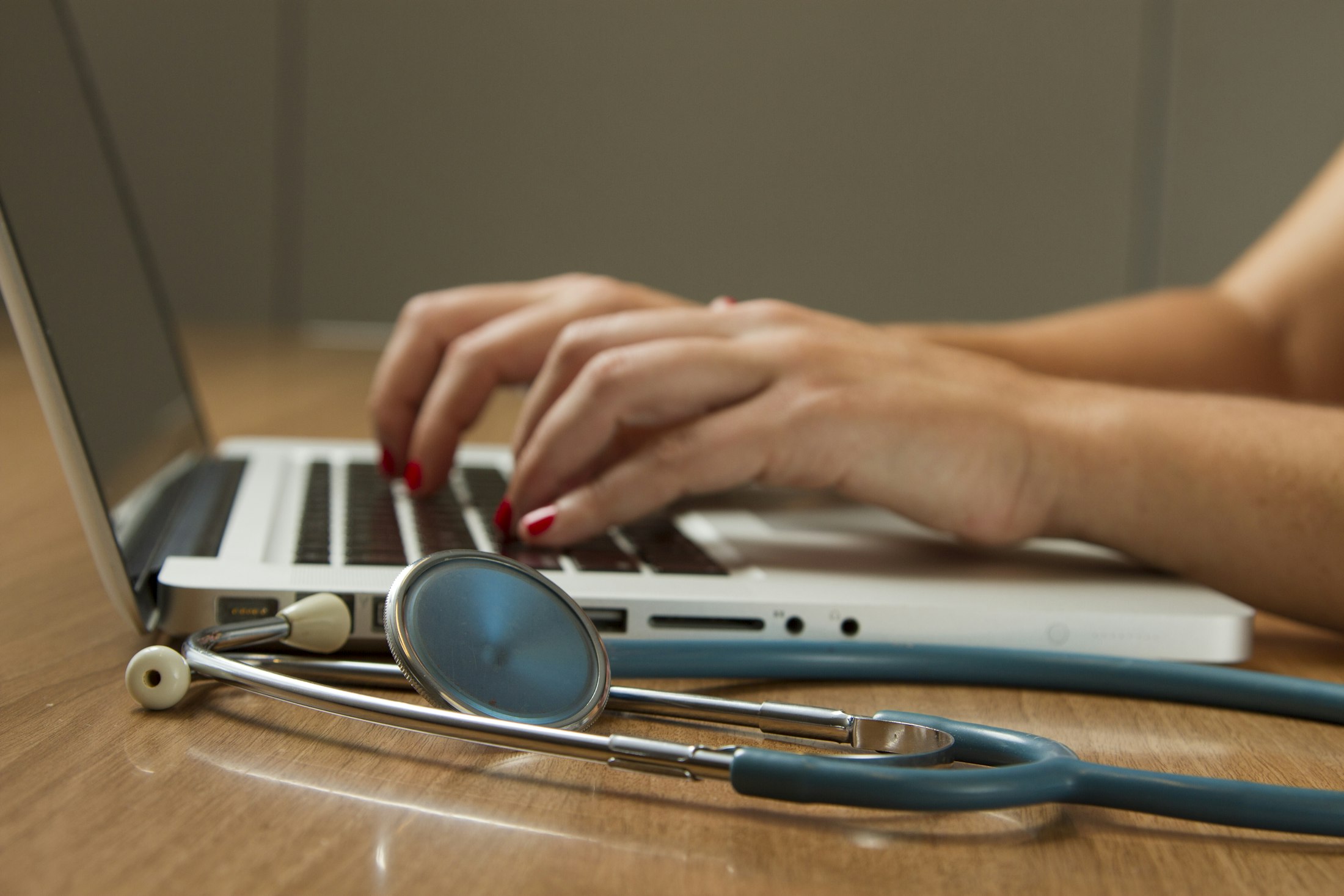 Healthcare IT: Arbeiten am Laptop mit Stethoskop im Vordergrund